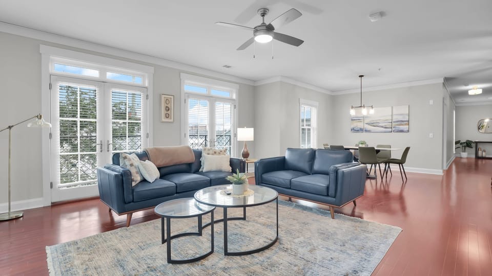 Spacious open living and dining area with modern décor, large windows, and natural light.