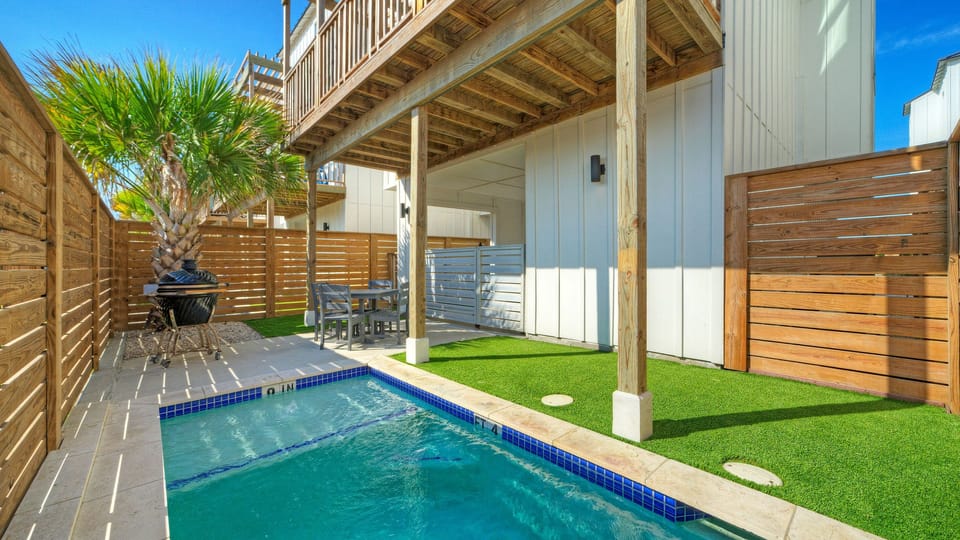 Private backyard featuring a small plunge pool, patio furniture, and artificial turf.
