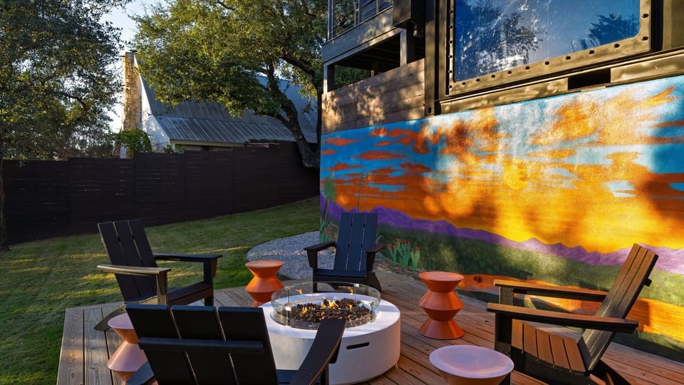 Gather around the fire pit beneath a vibrant mural—an outdoor lounge made for golden hour and late nights.