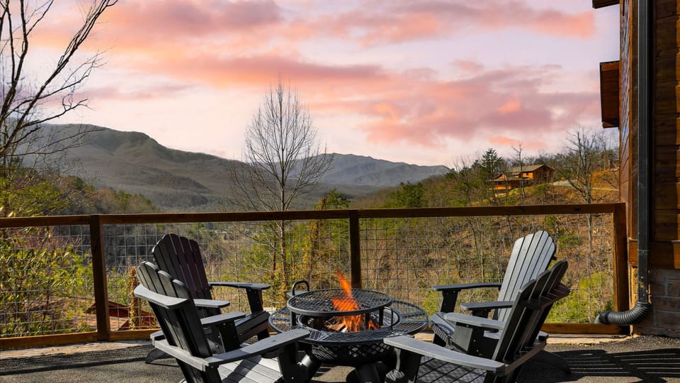 Adirondack chairs surrounding a fire pit on the deck with mountain views.
