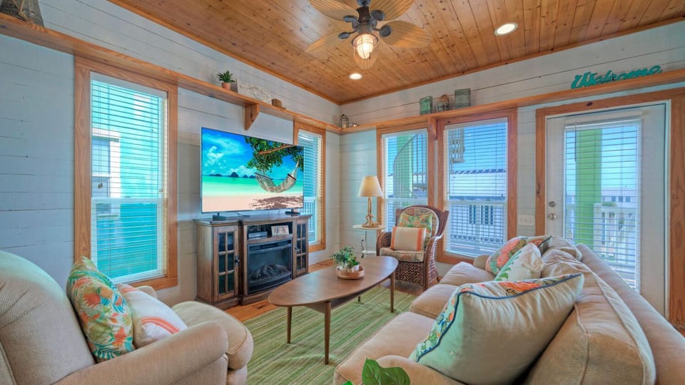 Main House: Cozy living area with plush seating, wood-paneled ceilings, and large windows.