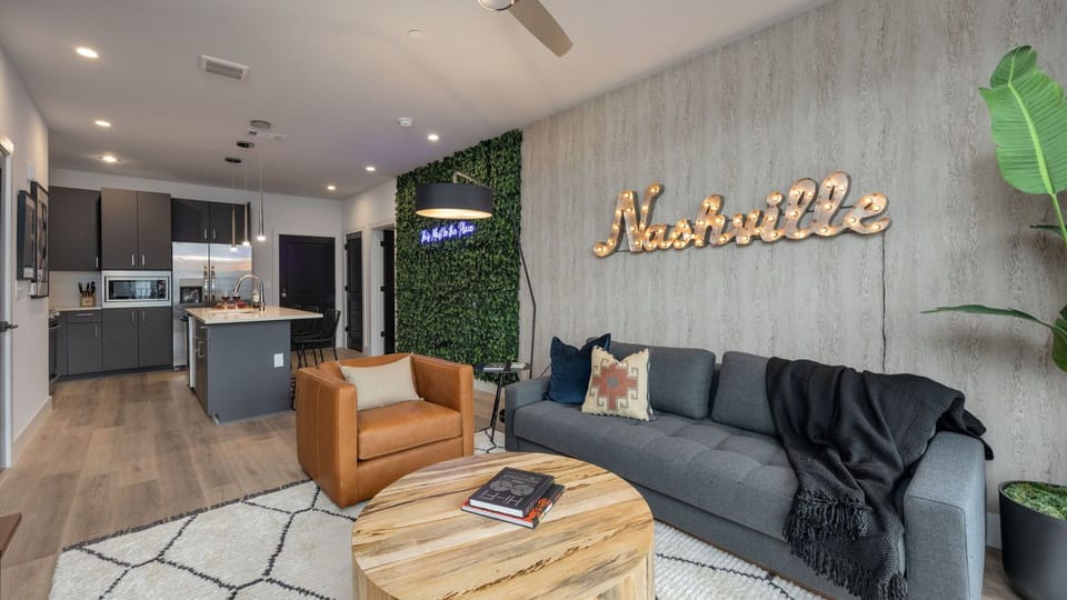 Chic living room detail showcasing the leather accent chair and the large "Nashville" wall art.