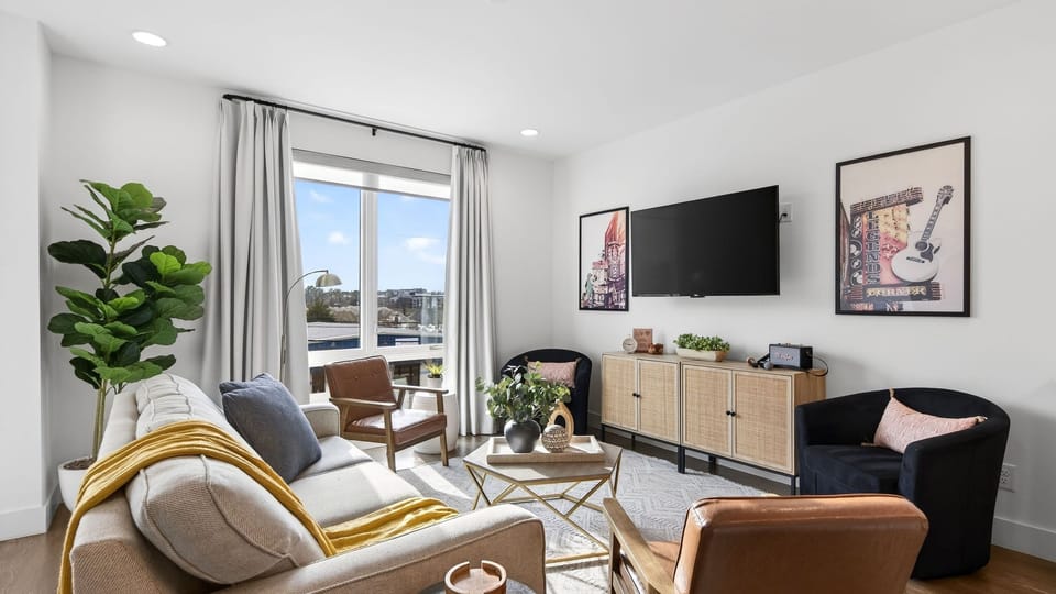 A bright, inviting living area with a queen sleeper sofa and large windows that bring in natural light.