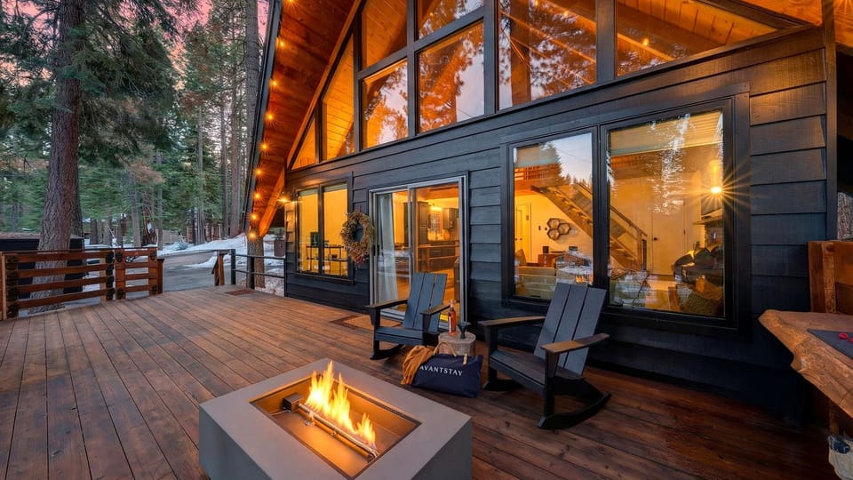 Spacious wooden deck featuring an outdoor firepit and forest view.