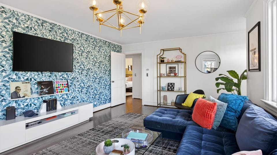 Stylish living room with plush sectional, large TV, and designer accents.