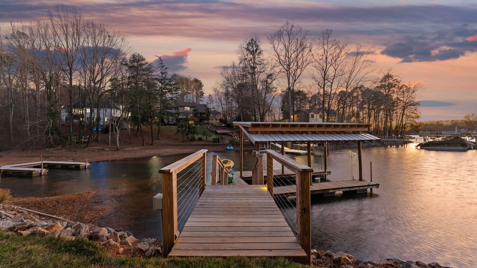 Private wooden dock and boat house at twilight.