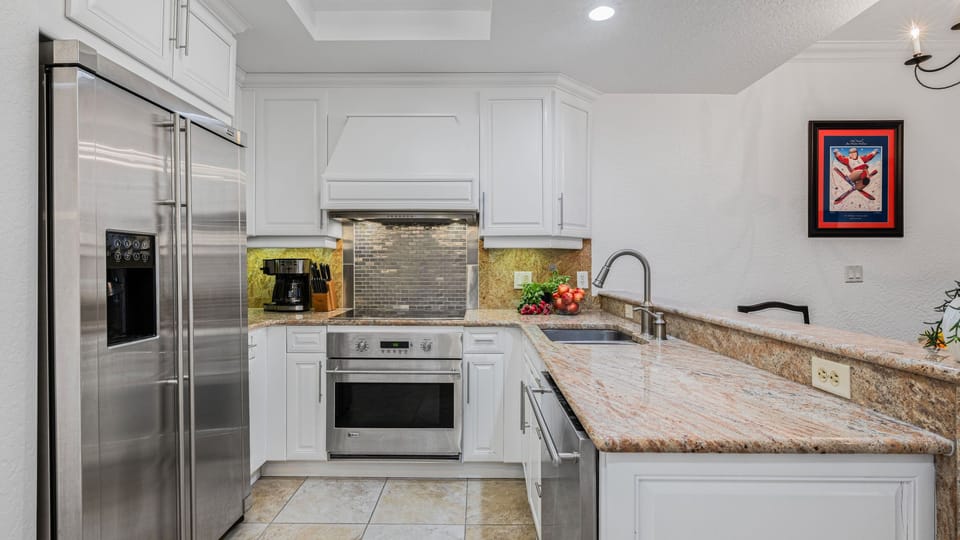 Modern kitchen with spacious countertops and stainless steel appliances.