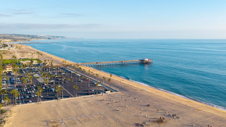 Aerial view of the surrounding coastline, beach, and pier.