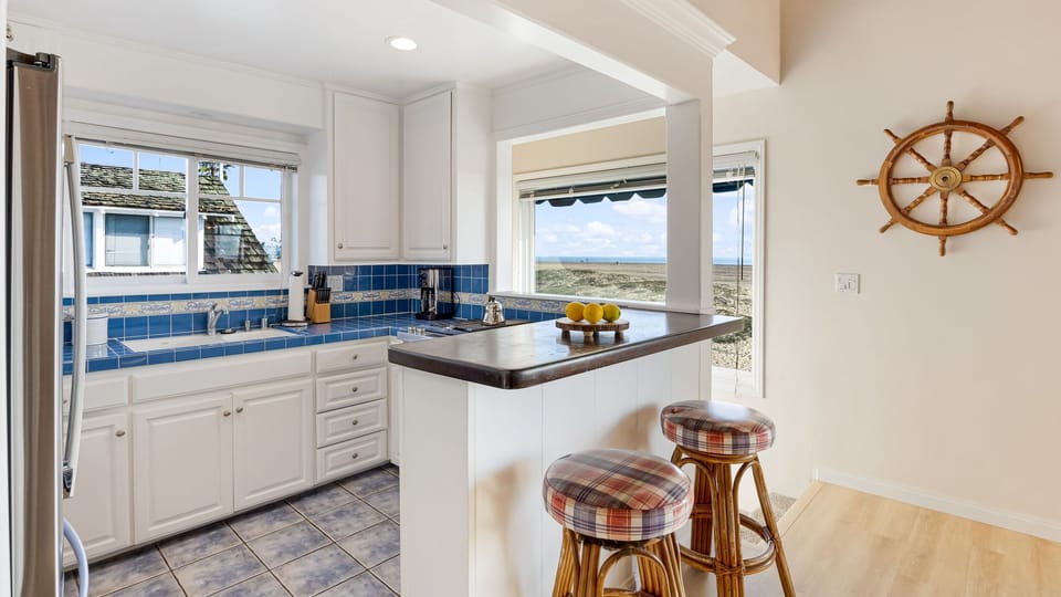 Bright coastal kitchen with breakfast bar and ocean views.