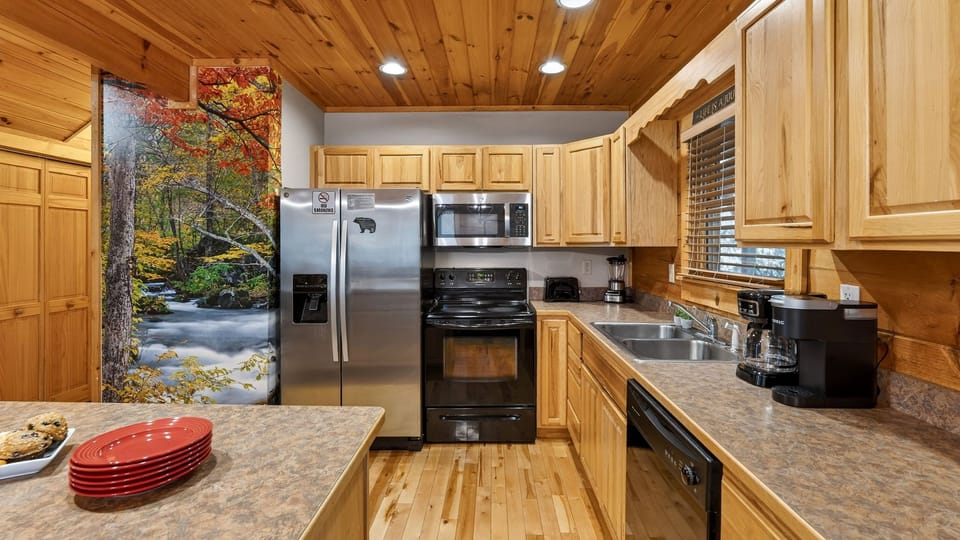 Fully equipped kitchen with stainless steel appliances and wood cabinetry.
