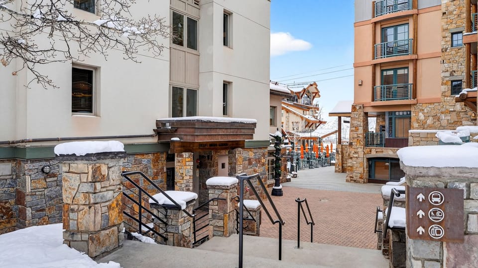 Exterior view of the lodge entrance and walkway nestled in a charming alpine village setting.