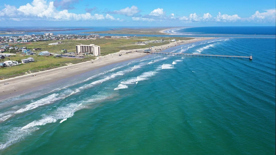 Distant aerial view of the Port Aransas coastline and pier.