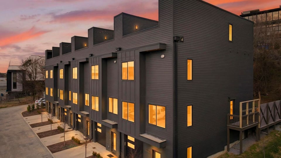 Modern Nashville townhomes glowing at dusk, just minutes from the city.
