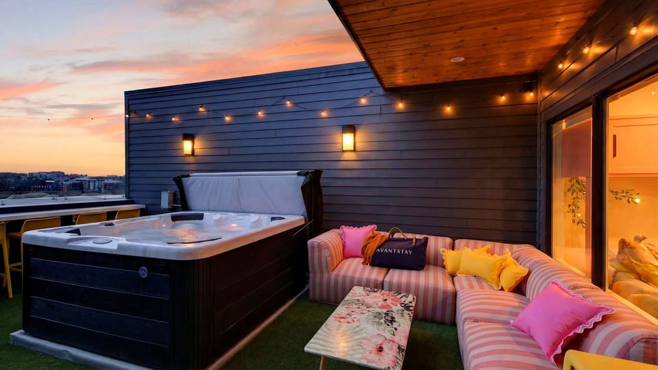 Rooftop hot tub with skyline views, string lights, and sunset vibes.