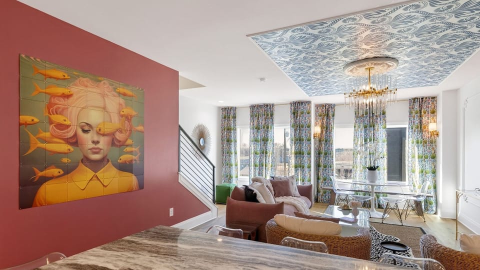 Stylish living room with statement ceiling, chandelier, and lounge seating.