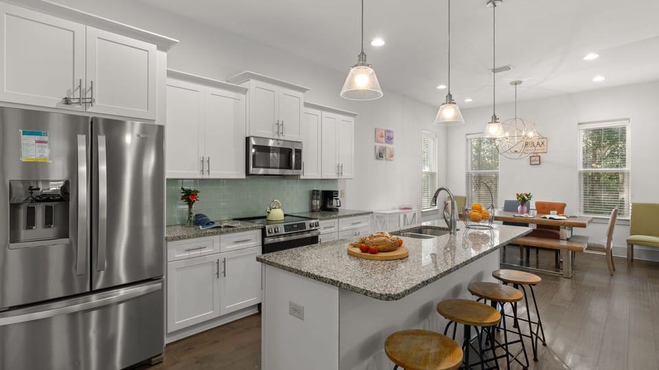 Modern, open-concept kitchen with stainless steel appliances and a spacious island with seating.