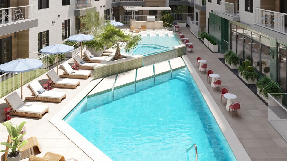 Elevated view of the resort offers a communal pool, outdoor kitchen, and multiple lounge areas.