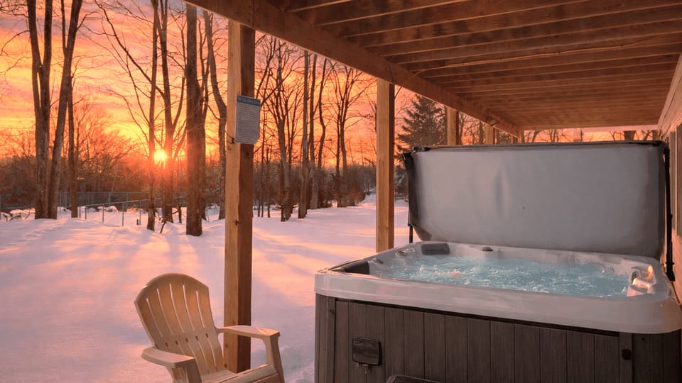 Private outdoor hot tub tucked under the deck, perfect for snowy evenings.