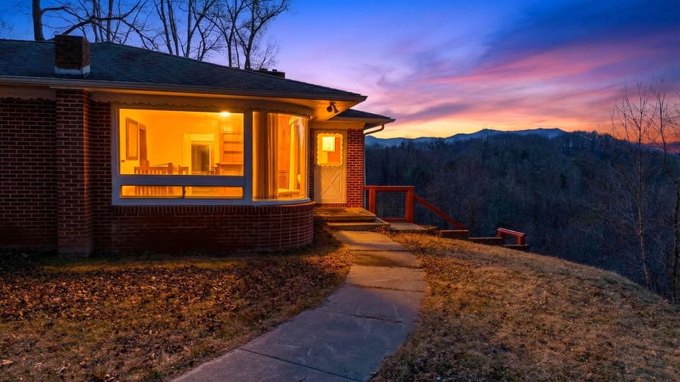 Blue Ridge sunset views + warm cabin glow—your Asheville retreat to unwind after a day of exploring.