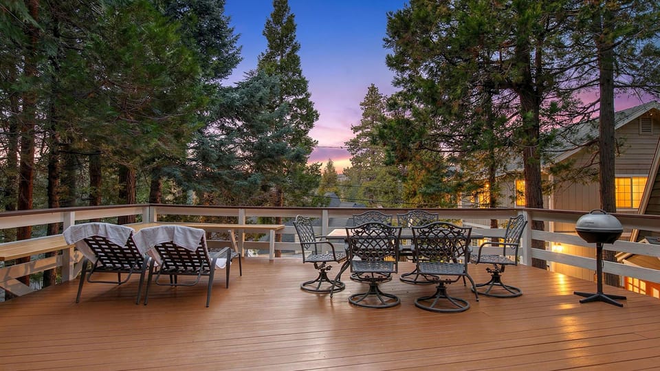 Golden hour on the expansive treetop deck — grill, dine, or lounge beneath the pines as the sky fades into a peaceful Lake Arrowhead sunset.