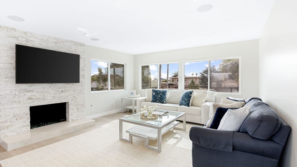 Secondary Living Space - A bright, airy seating area with white sofas and large windows.