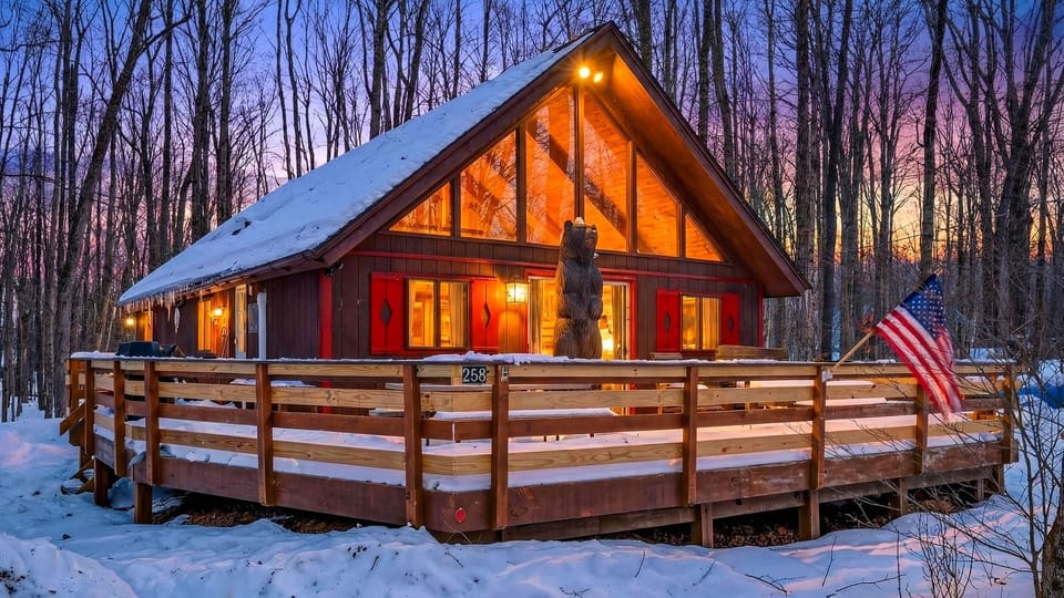 The cabin illuminated against the twilight snow.