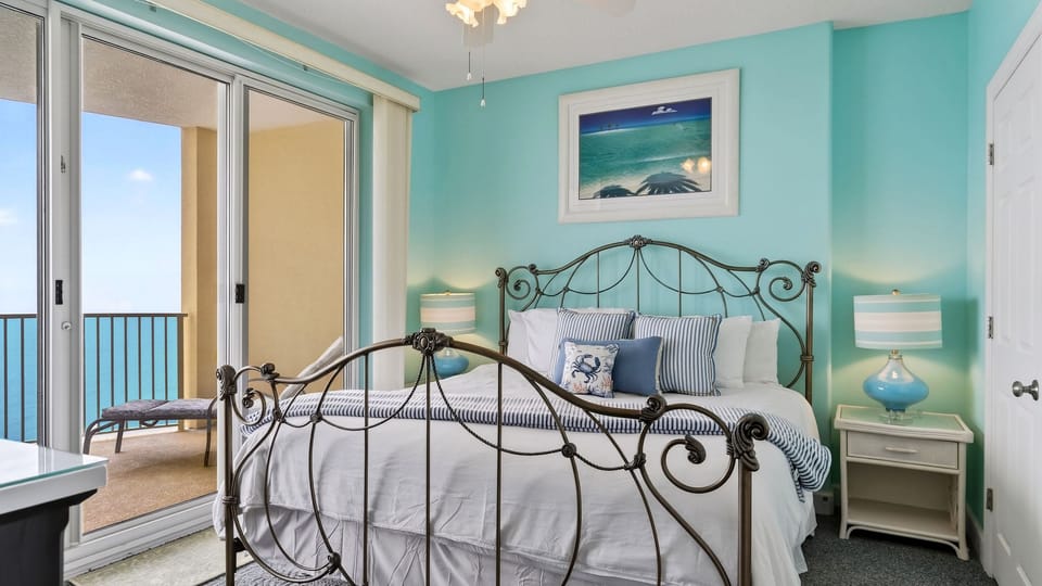 The primary bedroom features a king bed, a TV, and balcony access.