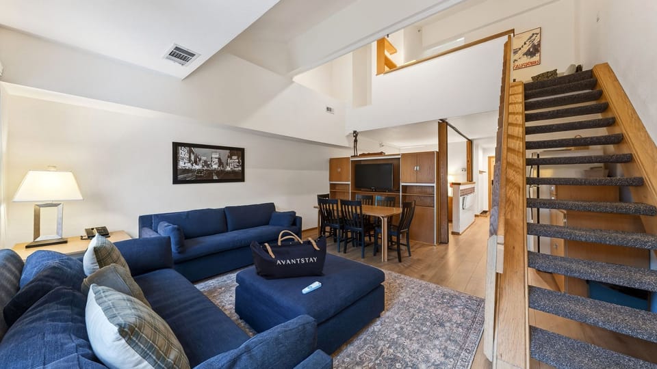 Bright and inviting living space with 2 sleeper sofas, vaulted ceilings, and large windows that bring in natural light and treetop views.