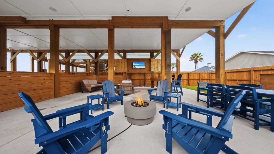 Your private backyard hangout—covered lounge, fire pit circle, and big-screen vibes for game night on the patio.