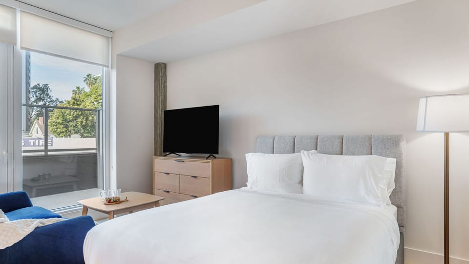 Retreat to a stylish sanctuary featuring plush bedding and expansive windows for natural light.