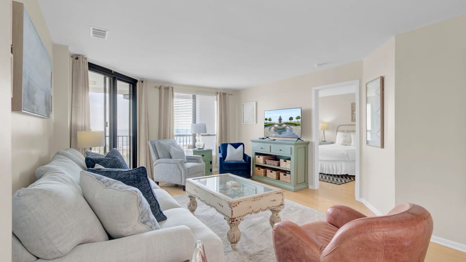 Main living area featuring a blue sofa and balcony access.