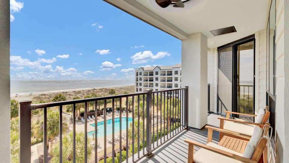 High-angle shot of the pool area and ocean from the private balcony.
