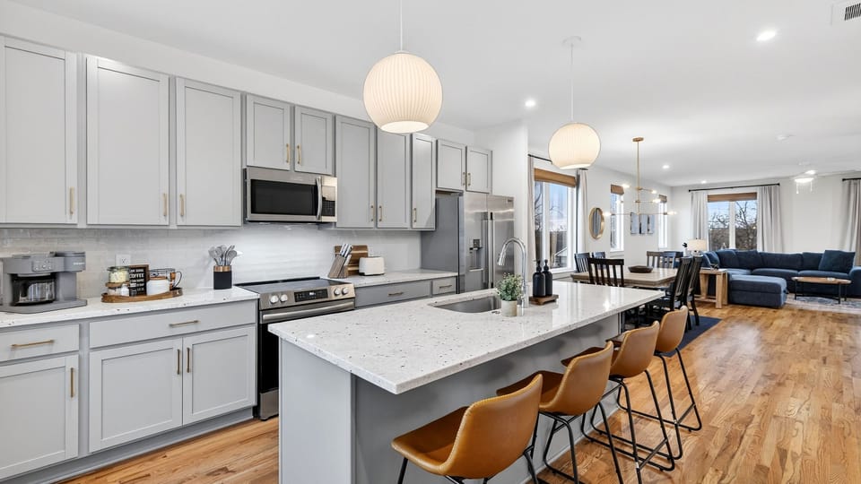 The bright open-concept kitchen features a large island with seating and flows seamlessly into the dining and living areas.