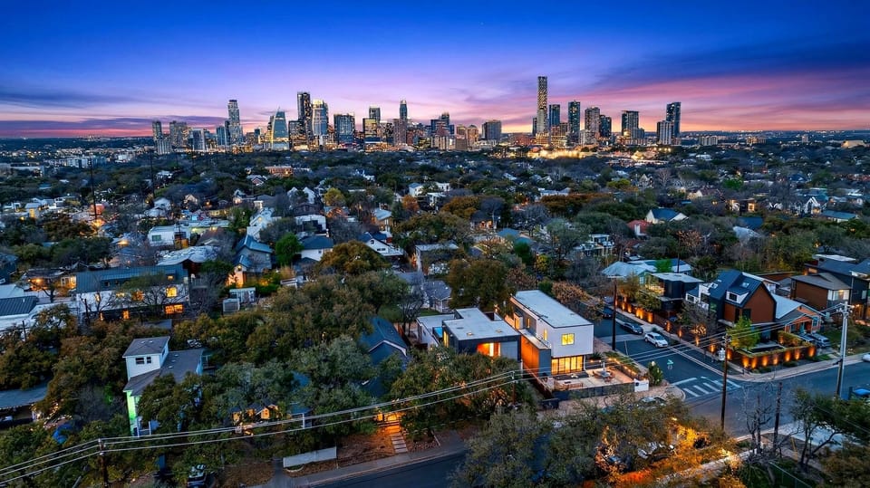 Sleek modern kitchen with statement tile, oversized island, and a dining setup made for gathering.
