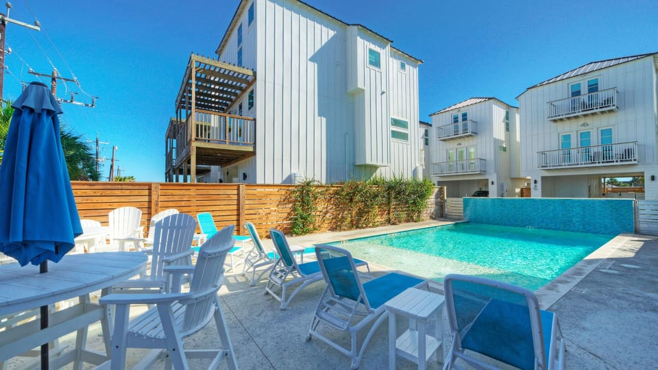 Shared community pool with lounge seating, just steps from the home.