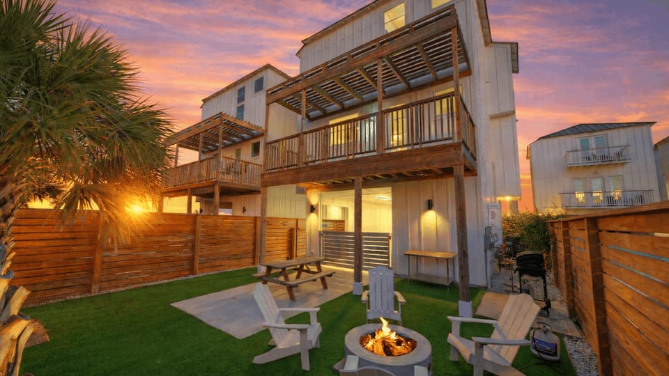 Private fenced backyard with firepit, outdoor seating, and covered patio. (Dune & Done)