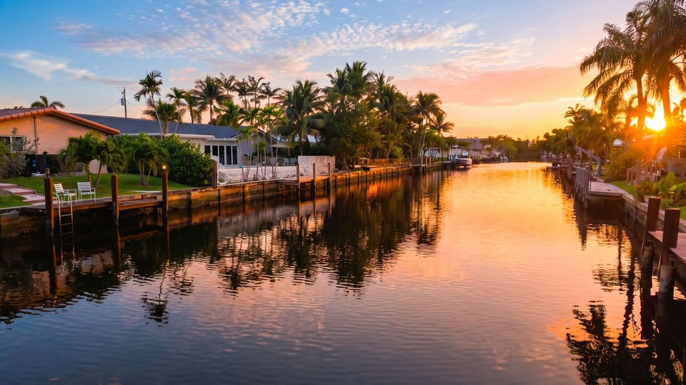 Sunset canal views with palm-lined homes and peaceful waterfront scenery.