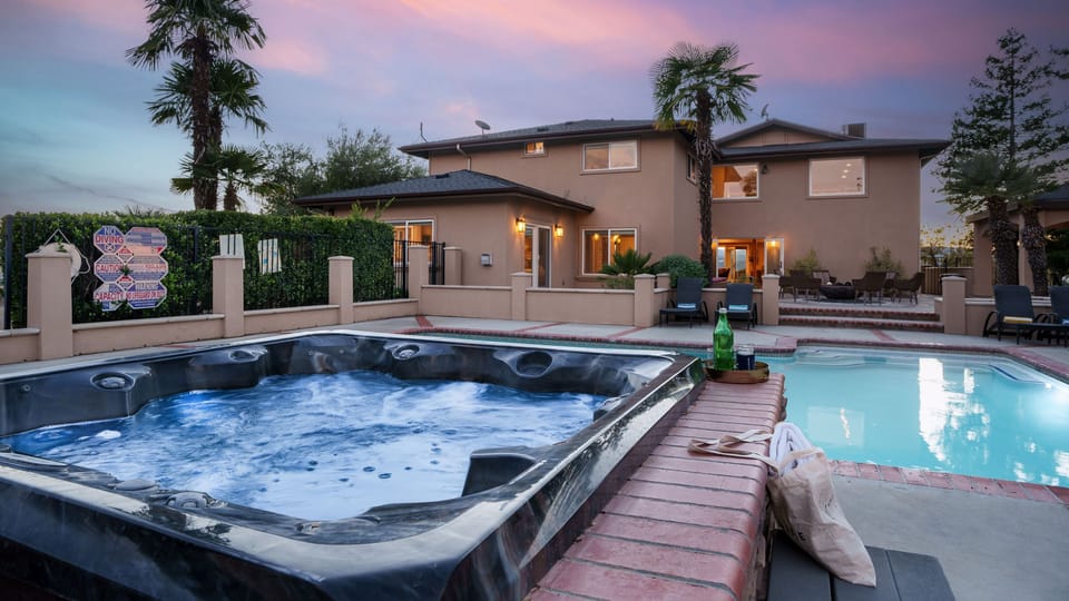 Close-up of the outdoor hot tub overlooking the pool area at dusk. (Main house)