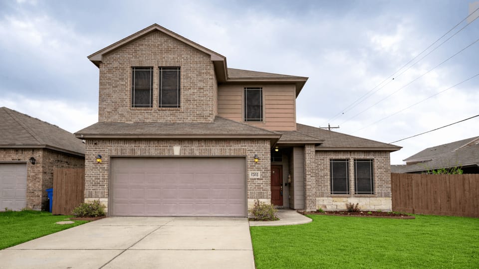 Clear view of the front of the house and manicured green lawn.