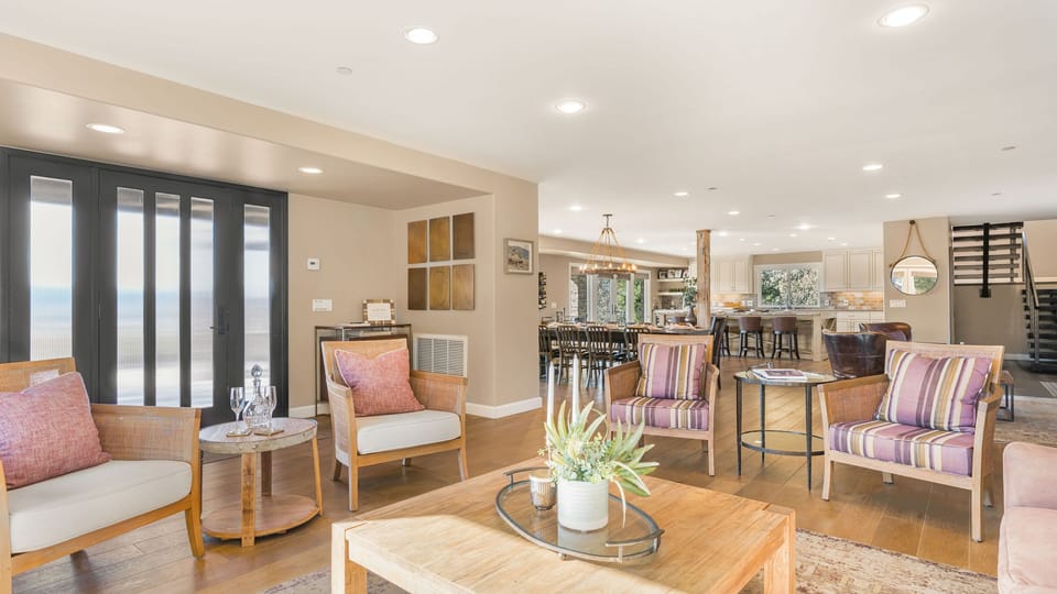Airy sitting room featuring comfortable armchairs and a large wooden coffee table, Main house.