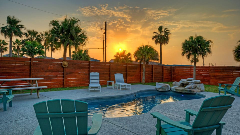 Private backyard oasis with pool, lounge seating, and stunning Port Aransas sunsets.