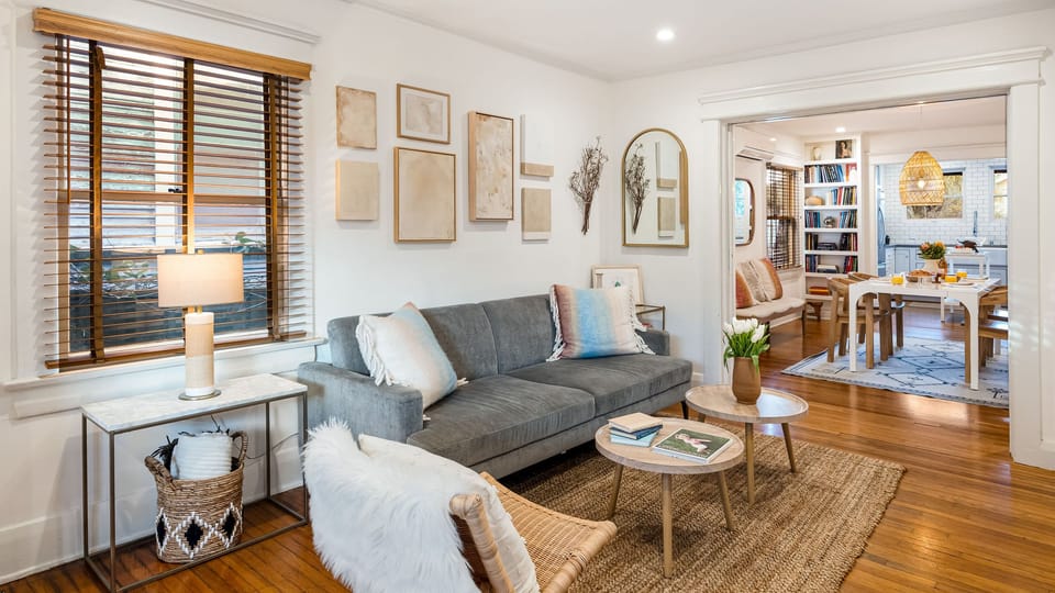Cozy sitting room with warm natural light, sleeper sofa and an easy flow to the dining area and kitchen.