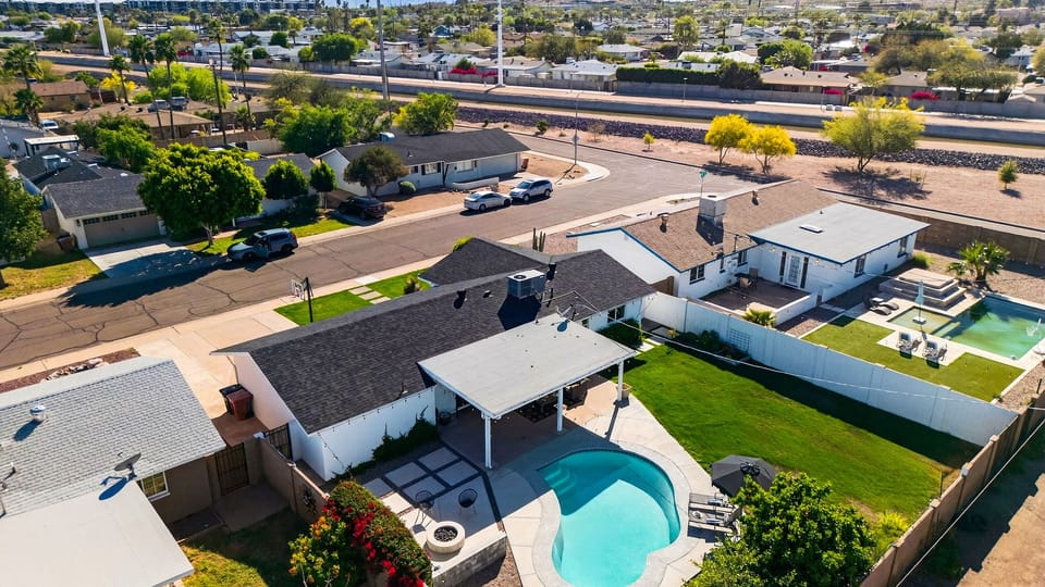 High-angle shot showing the private backyard, pool, and surrounding neighborhood.