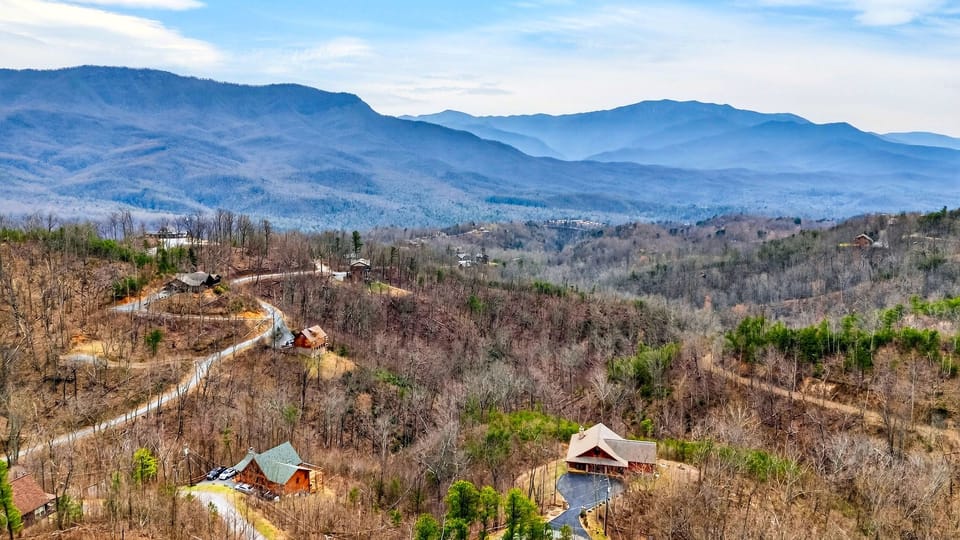 Sweeping landscape view of the surrounding mountain range and nearby cabins.