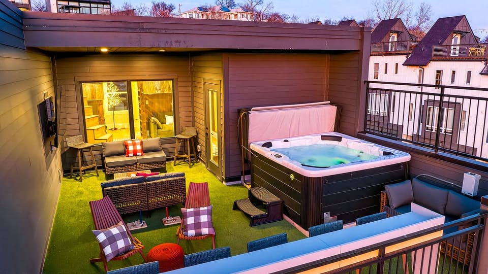 Rooftop oasis at golden hour—hot tub, lounge seating &amp; city vibes. (The Lodge)