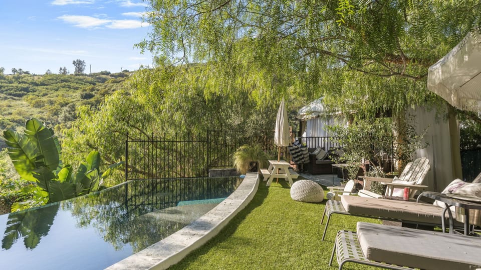 Infinity pool edge overlooking a green canyon valley.