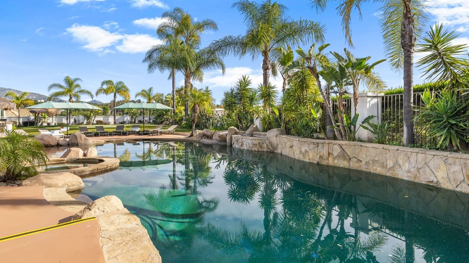 Resort-style pool framed by swaying palms, lush landscaping, and plenty of space to lounge in the Temecula sun.