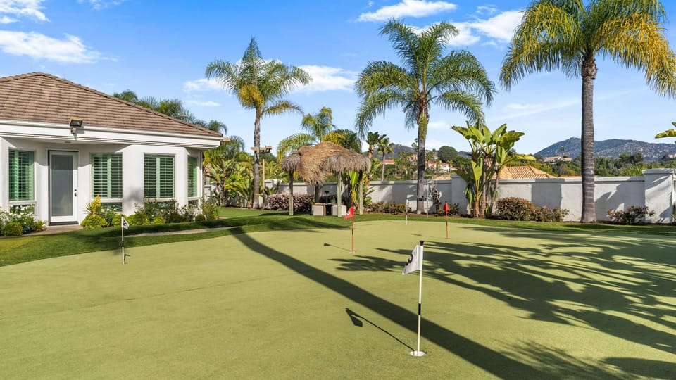 Private putting green surrounded by palms and mountain views — a fun, sun‑soaked Temecula backyard escape.