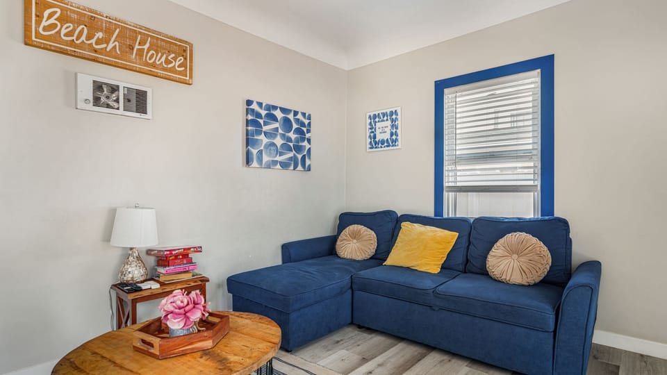 Relax in the bright and airy living room, featuring a comfortable sectional and coastal decor.