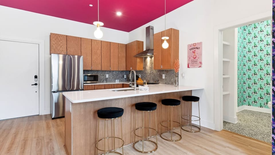 Unit 102: A stylish kitchen with bar seating, stainless steel appliances, and playful design touches.